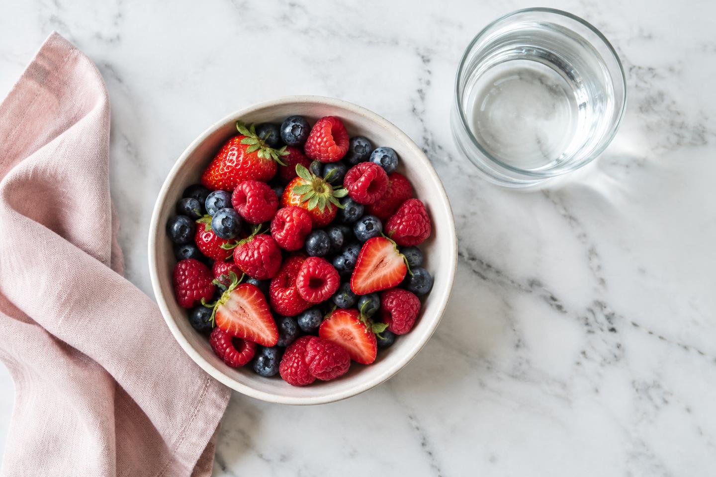 Fresh berries and a glass of water illustrating whole-food nutrition and hydration